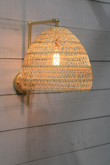 gold/brass wall light with woven rattan shade
