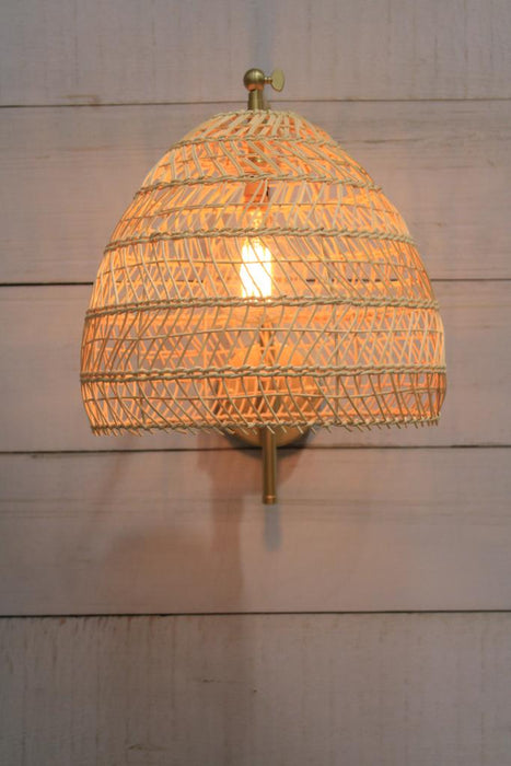 gold/brass wall light with woven rattan shade