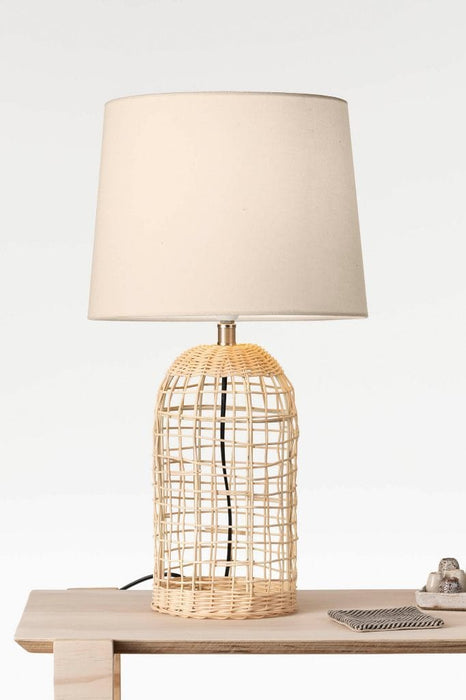 Woven cane table lamp on timber table