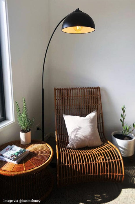 scandinavian arc floor lamp atop armchair