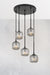 Five smoked glass pendant lights hanging from a black ceiling rose