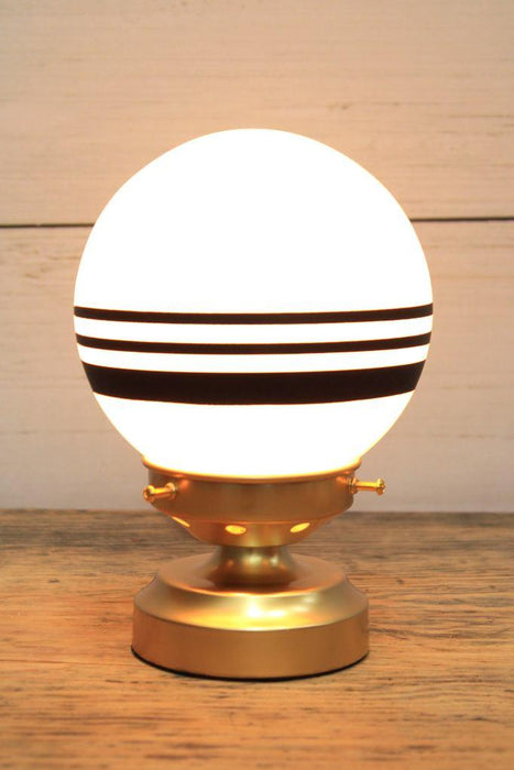 glass ball lamp with gold/brass base and 3 stripes