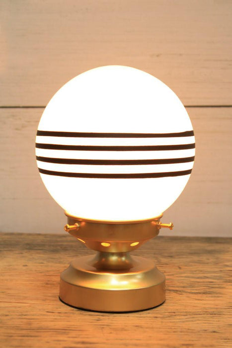 glass ball lamp with gold/brass base and 4 stripes