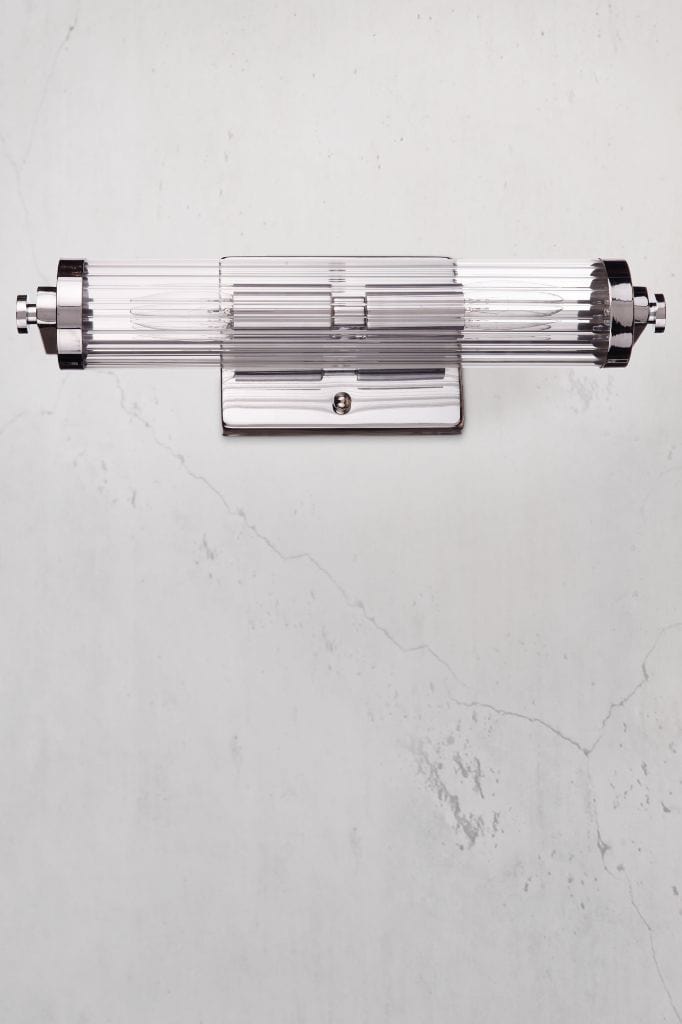 Horizontally installed Art deco vanity light with clear glass and a steel chrome finished bracket. 