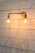 Gold steel double arm wall sconce with clear dome shades