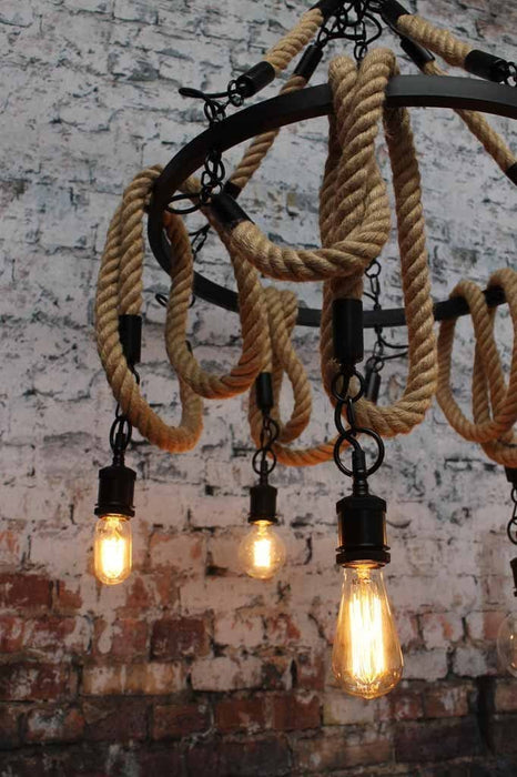 Rope chandelier made of metal the large circular ring holds five rope pendants. it is connected to the centerpiece of the light by five rope metal rods