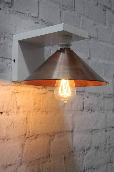 Vintage brushed copper shade with exposed bulb on white wooden wall sconce