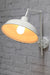 warehouse wall light with white arm and white shade in tilted position